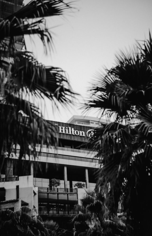 trees near Hilton building during daytime military gathering