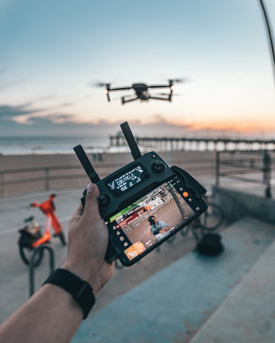 military man flying a DJI drone while holding remote