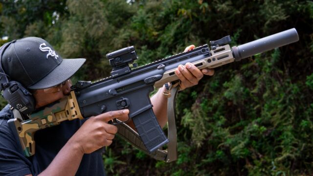 A man holding a gun and aiming it at something