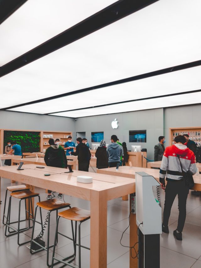 people standing and sitting inside apple store